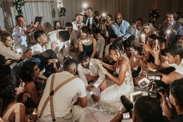 Wedding guests dancing on a packed dance floor with colorful lighting at a Southern Ontario reception